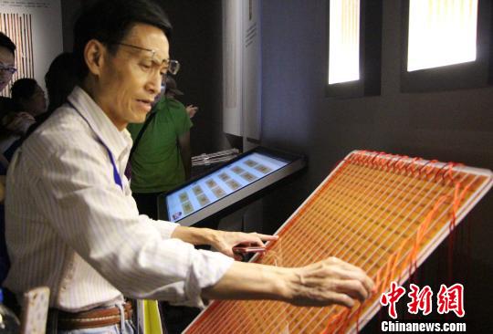 图为参展观众在现场体验古代算表的计算方式?！≌韵?摄