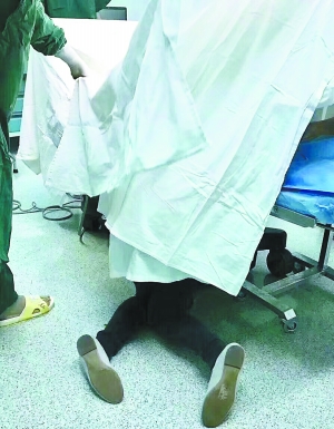 ▲事发当晚，王媚半跪在病床床尾一角，右手一直托举着产妇腹中的胎儿。