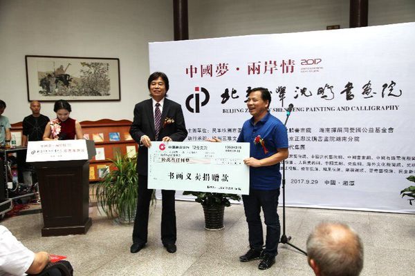 9月29日，在中国梦·两岸情画展开幕式上，民革株洲市委主委刘春正在接受北京正举沈鹏书画院院长沈鹏的义卖捐赠。
