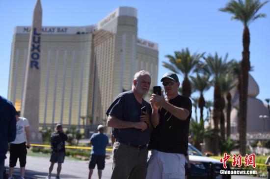 当地时间10月1日晚，美国西部旅游胜地拉斯维加斯发生枪击事件，一名枪手在曼德勒海湾酒店高层向正在参加露天音乐会的人群扫射，截至当地时间10月2日中午已造成50多人死亡。警方2日在曼德勒海湾酒店四周拉起警戒线，警车和全副武装的警察严阵以待，不少媒体记者和游客也聚集于此。 <a target='_blank' href='http://www.chinanews.com/'>中新社</a>记者 张朔 摄