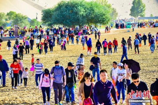 今年“十一”黄金周期间，丝绸之路国际旅游名城甘肃敦煌天气晴好，景色如画。敦煌深厚的历史文化和雄浑的大漠风光，吸引了大批海内外游客纷至沓来，敦煌旅游再度火爆。10月3日，鸣沙山月牙泉景区接待游客29524人次，创景区单日接待游客人数最高纪录。据敦煌市旅游局统计：截至10月3日，敦煌市共接待中外游客11.07万人次，同比增长17.14%，实现旅游收入1.12亿元，同比增长17.94%。其中，莫高窟接待游客51485人次，同比增长8.45%；鸣沙山月牙泉景区接待游客65386人次，同比增长13.75%；雅丹景区接待游客10787人次，同比增长18.93%；阳关景区接待8924人次，同比增长48....