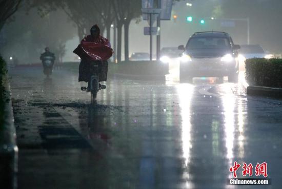 北京市民在雨中前行。 <a target='_blank' href='http://www.chinanews.com/'>中新社</a>记者 刘关关 摄