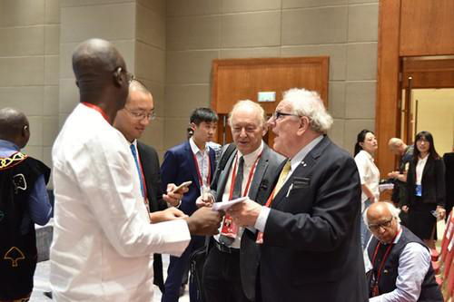 在人民日报社国际问题研究中心成立仪式上，与会专家在同马克林交流。孟祥麟摄