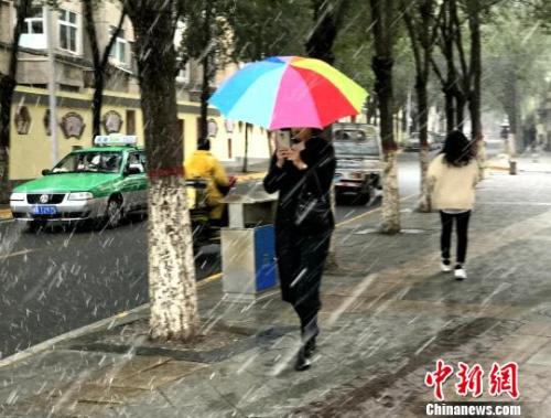 图为9日西宁市区飘起鹅毛般大雪，市民撑伞行走?！∷镱?摄