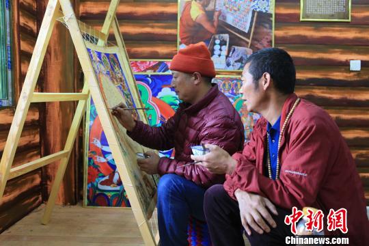 图为高佐甲泽与徒弟阿阿扎巴绘制唐卡?！⊥跖?摄
