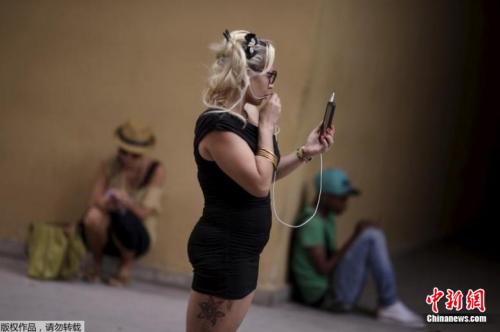 资料图片：人们拿着手机站在或坐在一个WiFi热点的附近。