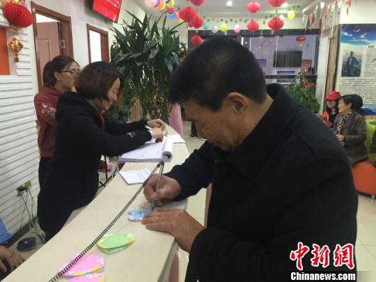 图为老人在便利贴上写下自己的心愿。　杨娜 摄