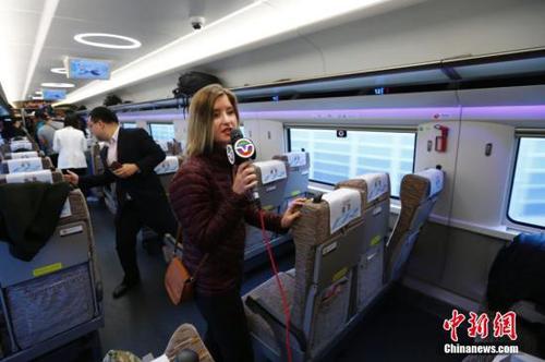 10月17日，美国中文电视台记者在京津城际高铁上采访。当日，十九大新闻中心组织中外媒体赴天津市围绕“京津冀协同发展情况”主题参观采访。采访团乘坐京津城际高速铁路赴天津文化中心、天津滨海新区中心商务区、天津申通物流公司等地，了解京津冀一体化建设在交通、商业等方面协同发展情况，以及中国高铁发展情况。 <a target='_blank' href='http://www.chinanews.com/'>中新社</a>记者 富田 摄