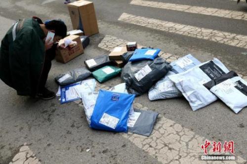 资料图：快递员在打电话联系收快递者。<a target='_blank' href='http://www.chinanews.com/'>中新社</a>记者 张远 摄