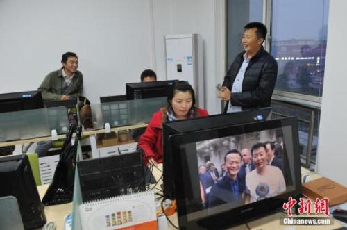 资料图：农民电商王小帮与加班的员工聊天。 <a target='_blank' href='http://www.chinanews.com/'>中新社</a>记者 韦亮 摄