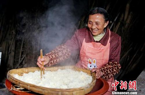 韩进先把蒸熟的糯米在筲箕中进行摊凉?！⊙钐?摄