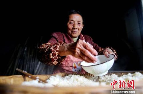 韩进先往摊凉的糯米中撒凉开水?！√瘴乃?摄