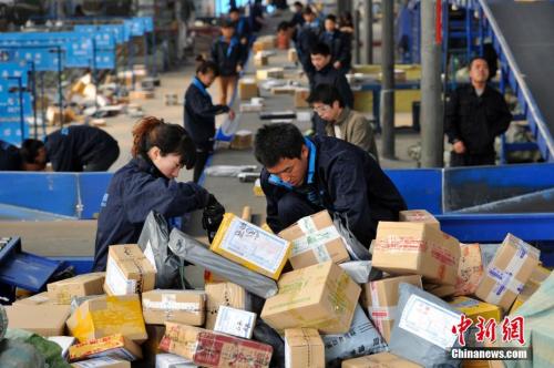 资料图：快递人员正在分拣大量包裹。 <a target='_blank' href='http://www.chinanews.com/'>中新社</a>记者 韦亮 摄