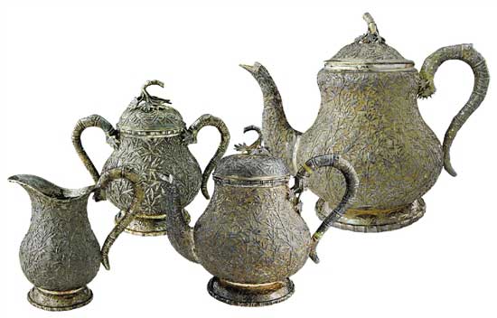 竹林摇曳茶具   Tea Set with Bamboo Forest Pattern　　咖啡壶 通高：18cm；腹径：13.5cm；重：727g   茶壶 通高：15.5cm；腹径：10.5cm；重：421g　　糖缸 通高：10.5cm；腹径：7.5cm；重：186g    奶缸 通高：9.5cm；腹径：6cm；重：131g　　款识：仪昌，伦巴 H    这套茶具使用了锤碟工艺，壶身通体附有竹枝竹叶，紧密相间，具有微风摇曳之动感，壶把手和流均为竹节附竹叶型。在茶具的细节之处体现了匠人的精心设计，银制茶具导热性极强，为防止茶壶把手过烫，凡是装热饮的茶壶、咖啡壶把手处都装有一白色象牙制圆环，俗称“象牙隔热”，用以阻断把手部分的热传导，做到美观大方与实用功能同时具备。壶体留有光面盾牌用以刻族徽，壶底外圈錾刻竹叶纹，有中国梅兰竹菊的款式风格在里面。该套茶具未经任何处理进行展示，表面留有一层氧化层，专业术语称之为“包浆”，以为对比之用。晚清外销银器盛极一时，但缺乏国内市场导致其很快衰落，至民国中后期逐渐销声匿迹，一方面是由于银器造价昂贵且国人没有使用银制器物的习惯，而另一方面则是银器需要大量的时间与精力进行维护，如若不经常擦拭，很容易表面氧化而失去光泽，这也使得银器的使用成本进一步提高，这正是银器逐渐没落的原因。可惜的是，中国传统手工业的传承大都是师徒制，而缺乏了市场需求的银器匠人招不到学徒，精湛的工艺面临着失传的窘境。