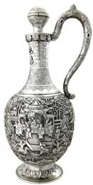 醒酒壶   Wine Decanter 晚清 通高：30.5cm；腹径：13cm；重：774g 款识：大吉     这件银壶造型独特，长颈鼓腹，通身锤揲有人物故事纹，颈部更錾刻有蕉叶纹、葡萄纹、竹枝纹，并贴焊“巴为刍夫”四字。整件器物仅有上方一球状壶塞的壶口，并无设计流口，都说明这并非盛装饮品的茶壶，而是一件醒酒壶。西方人不仅爱喝茶，同样也爱美酒，且更多的是饮用葡萄酒，葡萄酒内富含的单宁酸常常会使酒品尝的口感变涩，这也是葡萄酒需要“醒酒”这一程序的由来，而中国银匠为满足西方人的饮酒需要，创作出了银制的醒酒壶。有趣的是，醒酒需要让酒尽可能大面积的与空气接触，使得酒类的单宁酸迅速氧化挥发，而该壶并无此特点，这也是由于当时的银匠缺乏对葡萄酒的相关知识而造成的失误，只知有“醒酒”这道工序，而不知醒酒的原理，可谓是时代造就的一个美丽的误会。