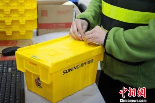 包装员正熟练地使用共享快递盒包裹商品?！≌韵?摄
