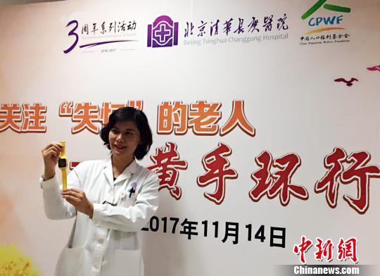 北京清华长庚医院首批29位患阿尔茨海默病的患者发放免费“黄手环”。图为北京清华长庚医院神经内科副主任医师张菁介绍“黄手环”用法?！《叛?摄