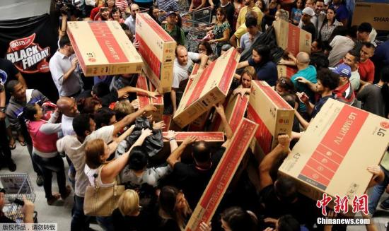 资料图：2016年11月25日，各国消费者迎来“黑色星期五”折扣日，民众倾巢出动来到大卖场，选购自己心水的货物。在众多商品中，大屏电视颇受青睐，几乎在每个卖场都能看到怀抱大电视的消费者。图为巴西圣保罗的一家商场里，大屏电视成为热门商品。