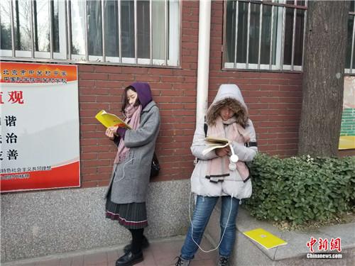 12月10日早7时30分许，北京市中关村中学(双榆树校区)，两名考生在室外进行考前复习。冷昊阳摄