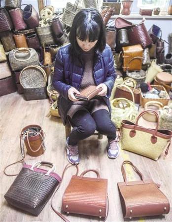 浙江省安吉县鄣吴镇依托青山、绿水、竹林，发展“绿色经济”。11月30日，鄣吴安吉心然竹木工艺品工作室负责人王蓉在查看手工竹编包。 新华社记者 徐 昱摄