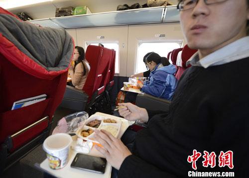 资料图：图为动车组乘客在品尝列车提供的餐食。<a target='_blank' href='http://www.chinanews.com/'>中新社</a>发 侯宇 摄