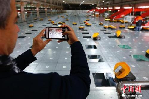 10月17日，中外媒体参观天津申通物流公司的“小黄人”分拣中心。当日，十九大新闻中心组织中外媒体赴天津市围绕“京津冀协同发展情况”主题参观采访。采访团乘坐京津城际高速铁路赴天津文化中心、天津滨海新区中心商务区、天津申通物流公司等地，了解京津冀一体化建设在交通、商业等方面协同发展情况，以及中国高铁发展情况。
<a target='_blank' href='http://www.chinanews.com/'>中新社</a>记者 富田 摄