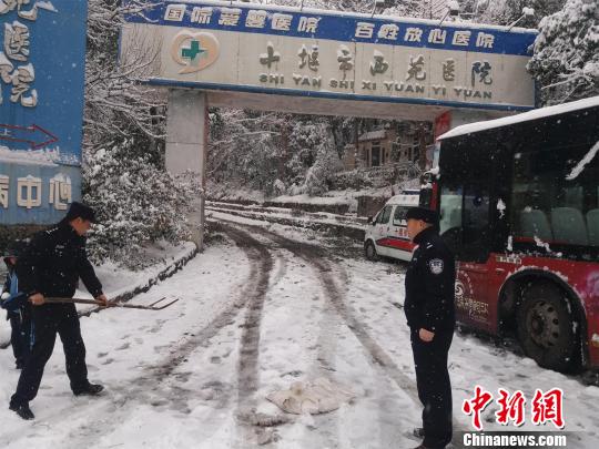 湖北十堰普降大雪，民警除雪保道路畅通 刘英 摄