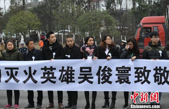 民众拉起横幅送消防英雄魂归故里?！×踔铱?摄