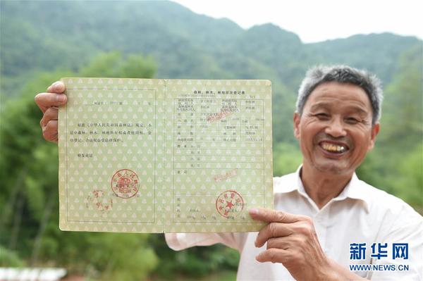 　福建武平县万安镇捷文村村民李桂林展示林权改革后领到的全国第一本新式林权证（2017年6月16日摄）。