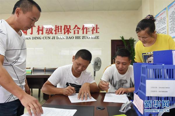 两名村民在福建武平县城厢镇园丁村村级担保合作社签订反担保合同（2017年6月15日摄）。