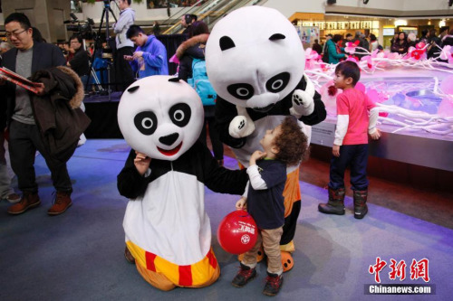 当地时间2月11日，加拿大第二大城市蒙特利尔举行欢乐春节庙会。图为现场工作人员扮演的“大熊猫”吸引当地“洋娃娃”的目光。这是蒙城连续第二年在农历新年前夕由华人社区联合举办欢乐春节庙会。参与筹办庙会的侨团由第一届的70多个增至本届的近百个。<a target='_blank' href='http://www.chinanews.com/'>中新社</a>记者 余瑞冬 摄