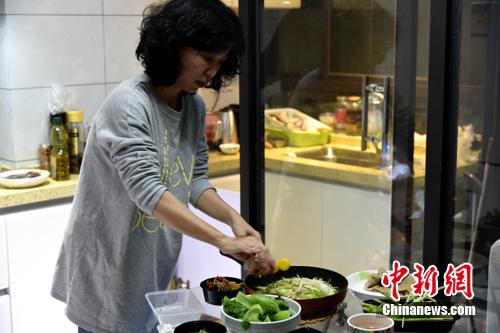 图为李妈妈在制作料理。 吕明 摄