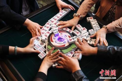 中国侨网资料图，巴蜀很多餐馆都提供麻将机，聚餐过后大家不打上几盘麻将是不愿离开的。在达州一餐馆内正在打麻将的人们。中新社发 熊然 摄