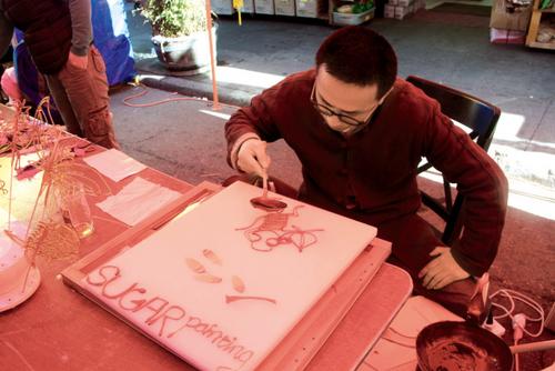 中国侨网“糖画”师傅现场作画，一分钟就画好了。（美国《世界日报》／李晗 摄影）