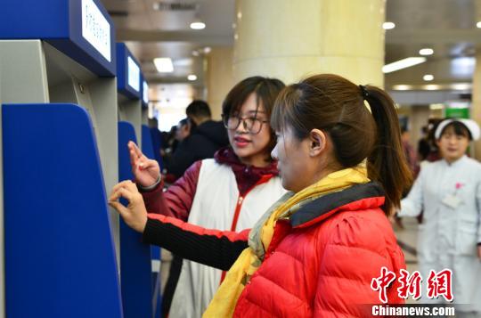 吉林大学中日联谊医院工作人员指导民众如何使用自助挂号、缴费终端。吉林省卫计委供图