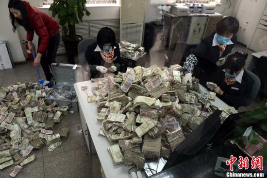  资料图为工作人员清点“毛票”。杜小伟 摄 图片来源：CFP视觉中国