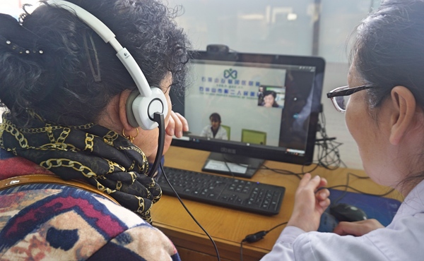 大武口区永乐社区卫生服务中心的社区医生正在帮助患者与上级医生交流病情