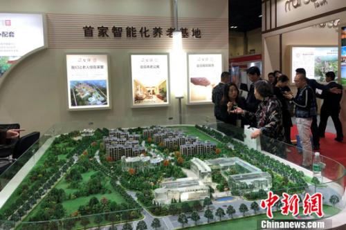 2018北京春季房展会上某养老地产项目的工作人员在向观众进行介绍。程春雨 摄