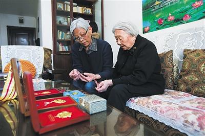 周智夫二女儿周卫平和母亲娄淑珍静静地端详着周智夫生前所获勋章。