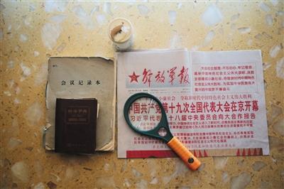 周智夫生前看的报纸、使用的放大镜、字典和笔记本。