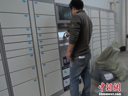 资料图：快递员使用智能快递柜投送包裹。韩章云 摄