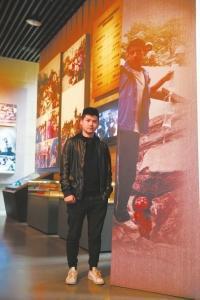 “吊瓶男孩”李阳站在十年前的照片前。