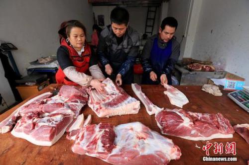 居民在家中切猪肉。谭凯兴 摄