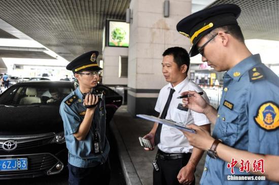 5月16日，广州市交通委员会执法局执法人员在广州东站对网约车相关资质进行核查。<a target='_blank' href='http://www.chinanews.com/'>中新社</a>记者 陈骥旻 摄