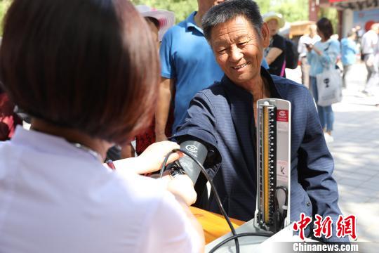 义诊医生在为市民测量血压?！『?摄
