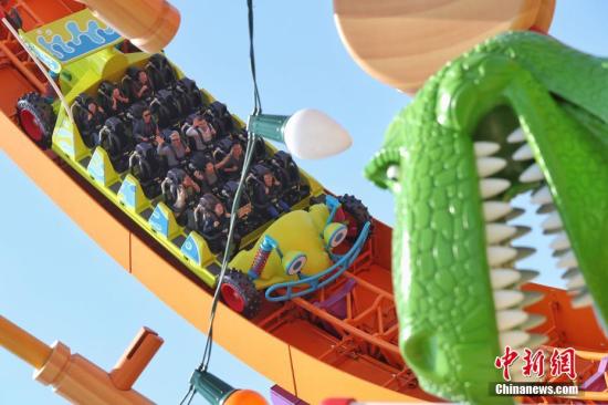 4月26日，上海迪士尼度假区迎来了乐园的第七个主题园区“迪士尼·皮克斯玩具总动员”主题园区全新开幕。据了解，新园区包括三个全新的景点——弹簧狗团团转、抱抱龙冲天赛车和胡迪牛仔嘉年华，一个独特的与迪士尼朋友见面的主题区域——友情驿站，以及提供沉浸式购物和餐饮体验的艾尔玩具店和玩具盒欢宴广场。图为游客在园区内游玩。<a target='_blank' href='http://www.chinanews.com/'>中新社</a>记者 张亨伟 摄