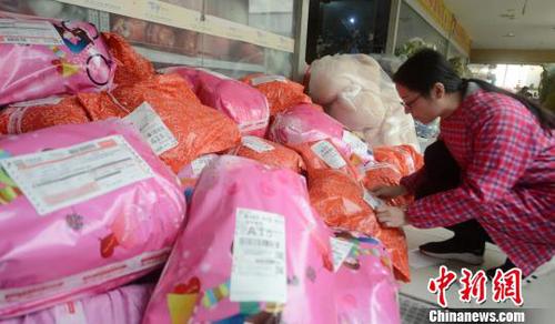 资料图：图为电商工作人员为包裹贴上快递单。(孟德龙 摄)