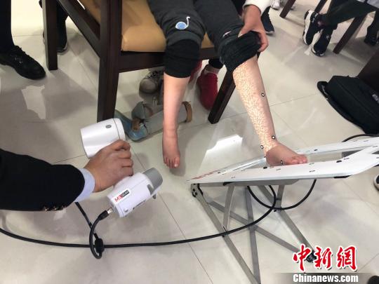 图为技师使用红外激光扫描取样。(资料图) 徐雪 摄