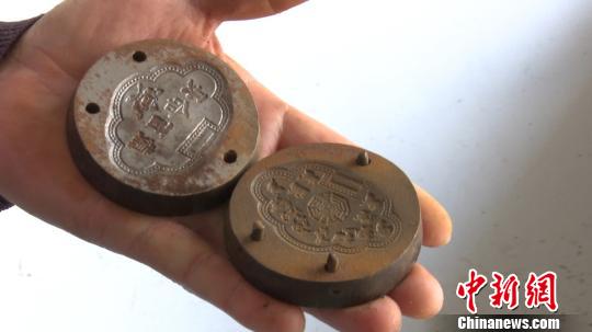 洪金泉向记者展示制作“长命锁”的模具 刘鸿鹤 摄