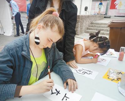 中国侨网6月10日，为期4天的第三届比利时列日省“中国城会”活动落下帷幕。图为列日大学的学生在活动现场学习书法。 本报记者 任 彦摄 
